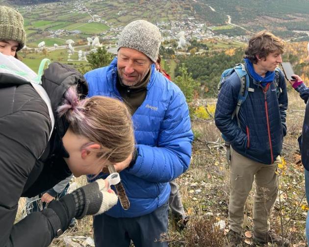 In the mountains of Switzerland, a student looks in a test tube of soil.